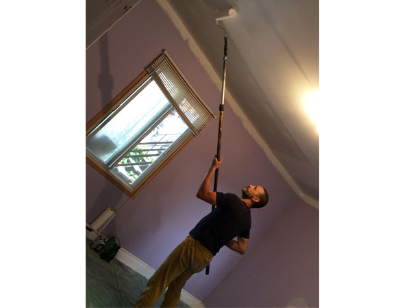 天井のペンキ塗りをするパートナー